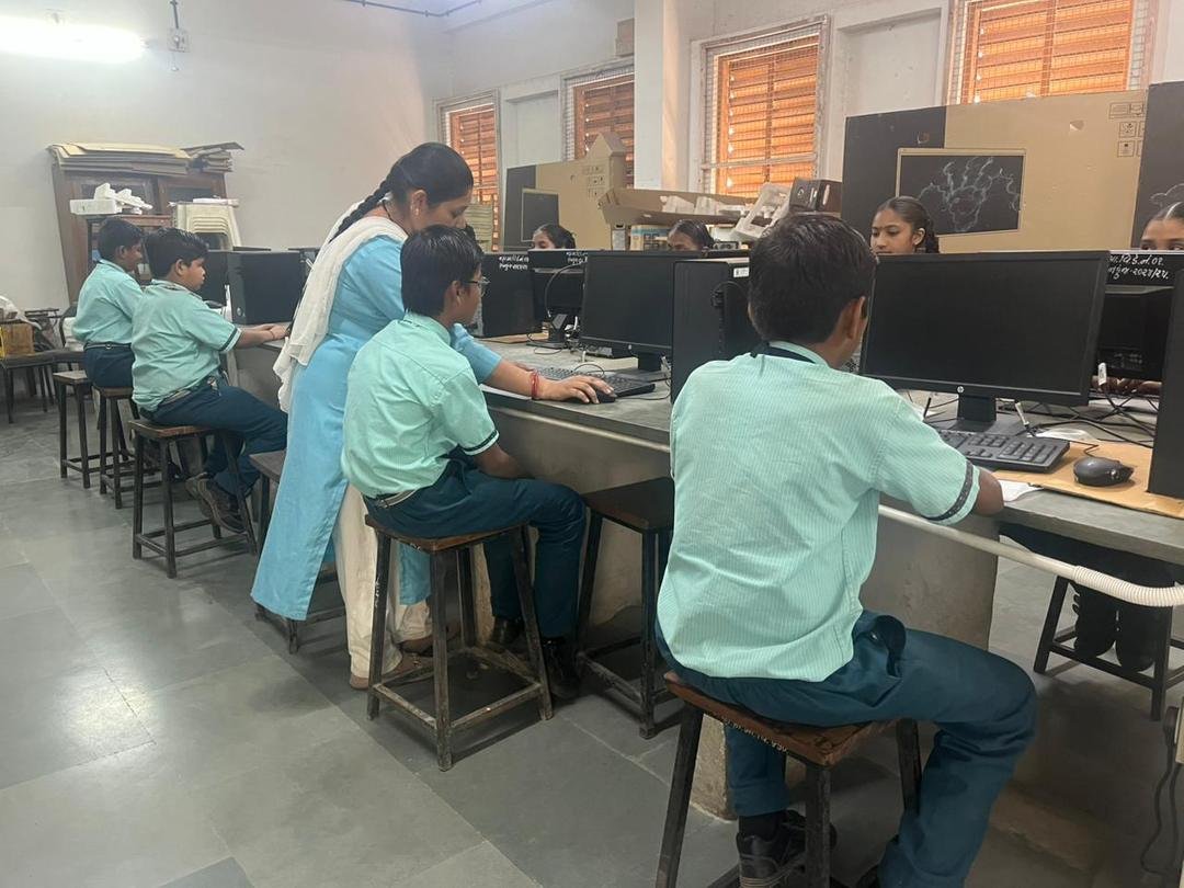 Teacher guiding students in the computer lab